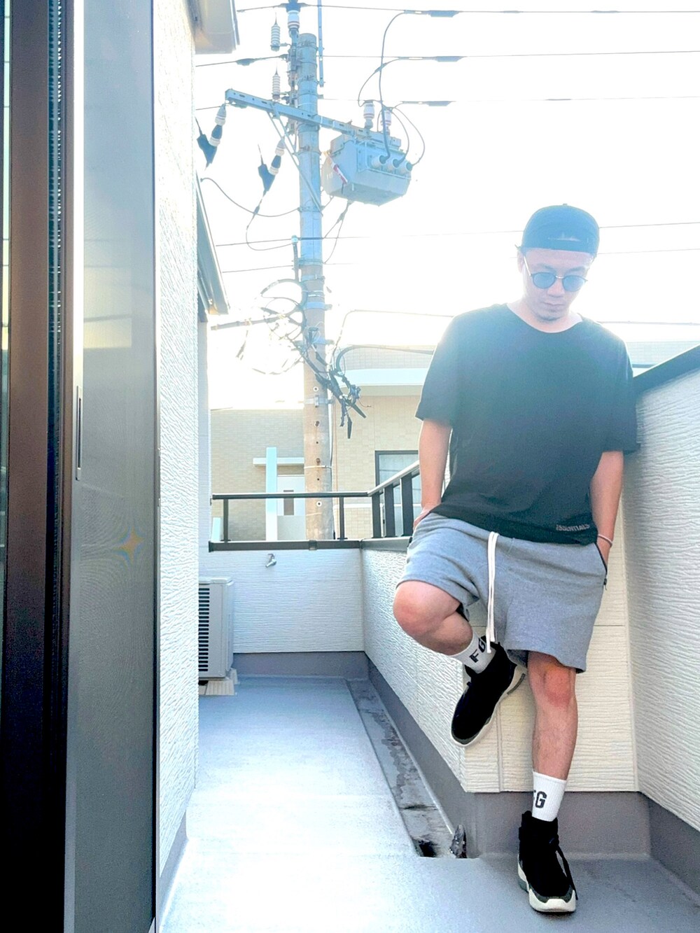 ブラック系のスニーカー、ブラック系のTシャツ/カットソー、グレー系のパンツを着用したメンズの夏コーディネートの4枚目の写真