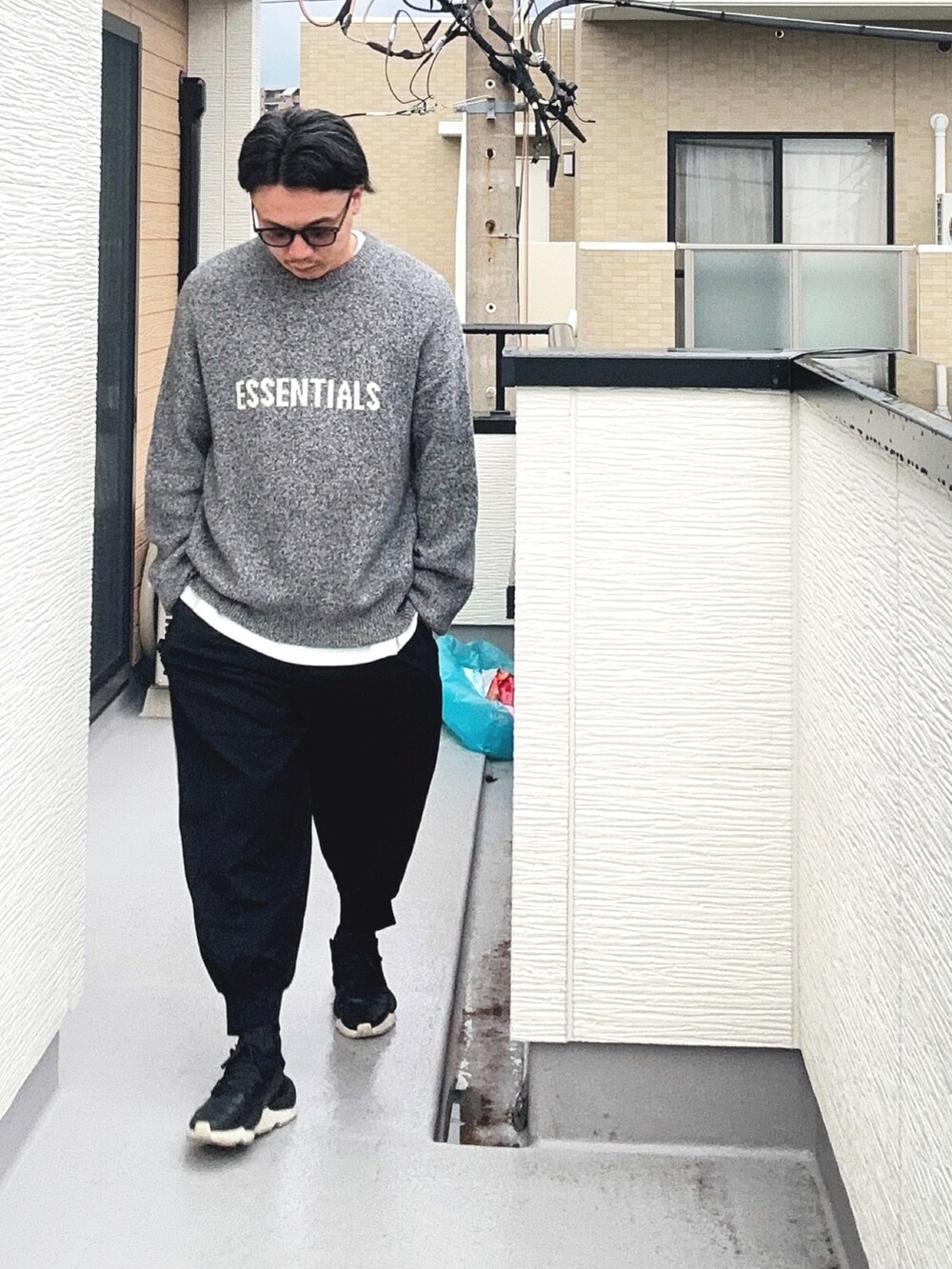 グレー系のニット/セーター、ブラック系のその他パンツ、ホワイト系のTシャツ/カットソーを着用したメンズの秋コーディネートの4枚目の写真