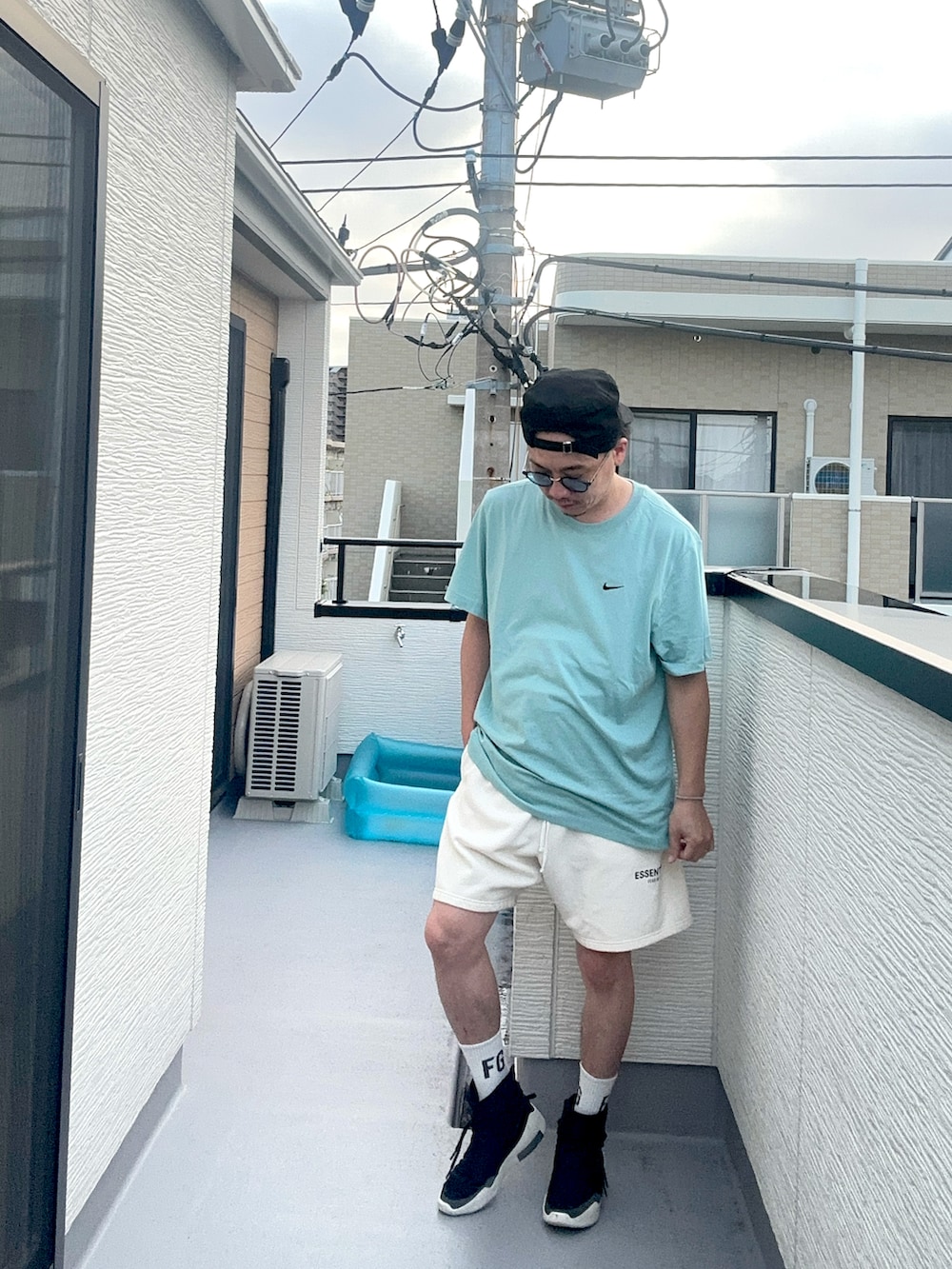 ブルー系のTシャツ/カットソー、ホワイト系のスウェットパンツ、ブラック系のスニーカーを着用したメンズの夏コーディネートの2枚目の写真