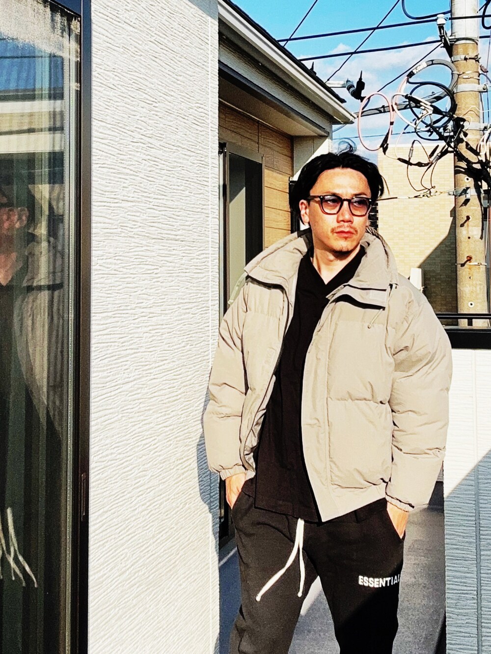 ブラック系のTシャツ/カットソー、グレー系のダウンジャケット/コート、ブラック系のスウェットパンツを着用したメンズの秋コーディネートの4枚目の写真