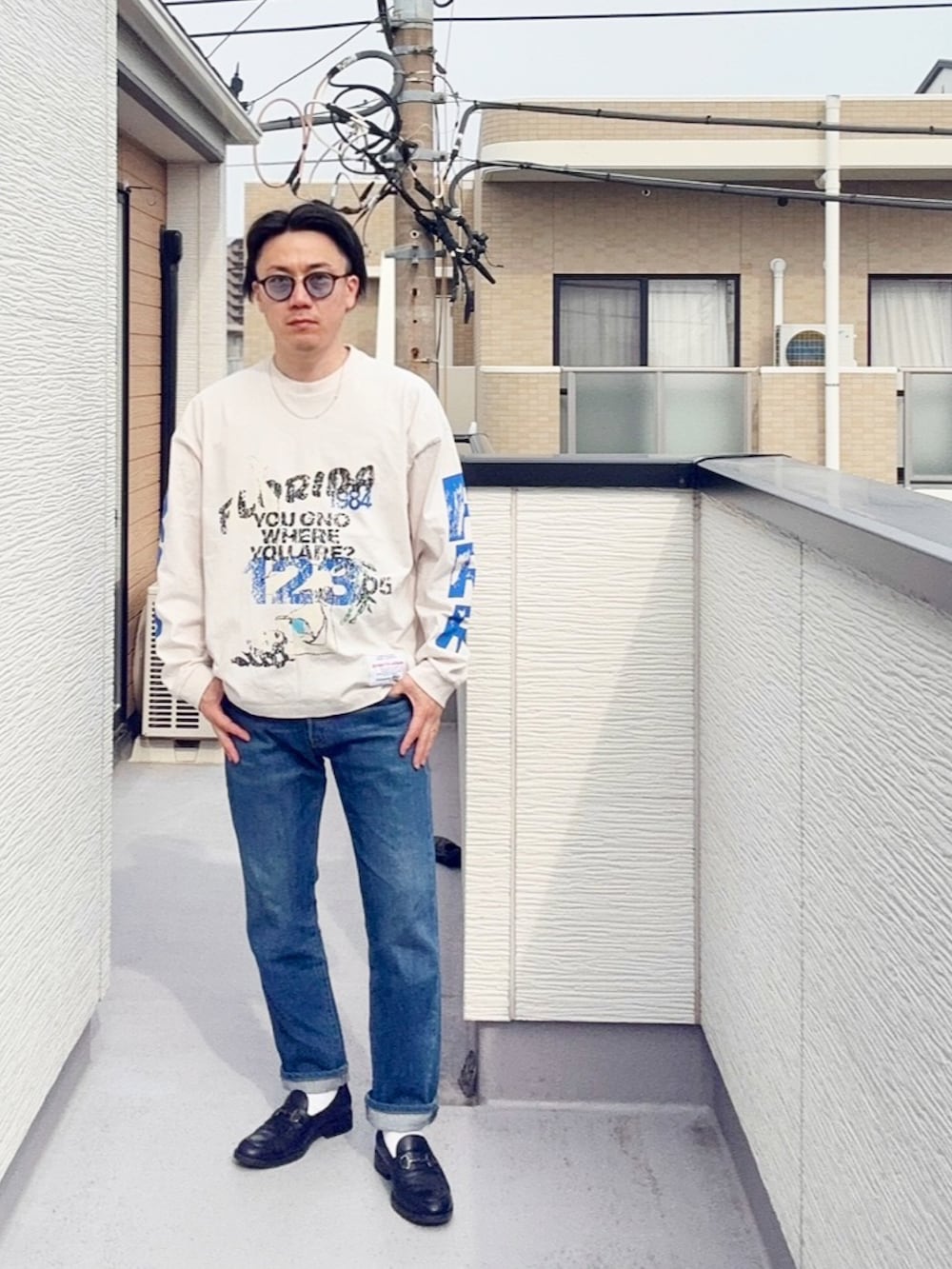 ブルー系のデニムパンツ、ブラック系のローファー、ホワイト系のTシャツ/カットソーを着用したメンズの春コーディネートの2枚目の写真