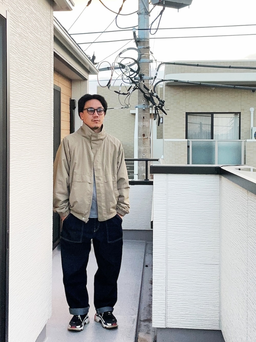 ベージュ系のブルゾン、グレー系のTシャツ/カットソー、ブルー系のデニムパンツを着用したメンズの秋コーディネートの2枚目の写真