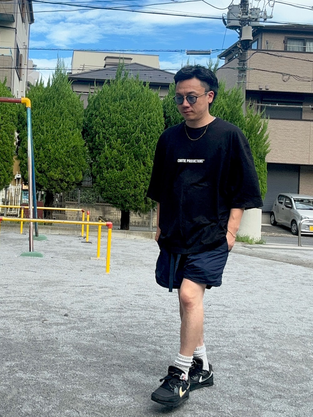ブラック系のTシャツ/カットソー、ブルー系のパンツ、ブラック系のスニーカーを着用したメンズの夏コーディネートの2枚目の写真