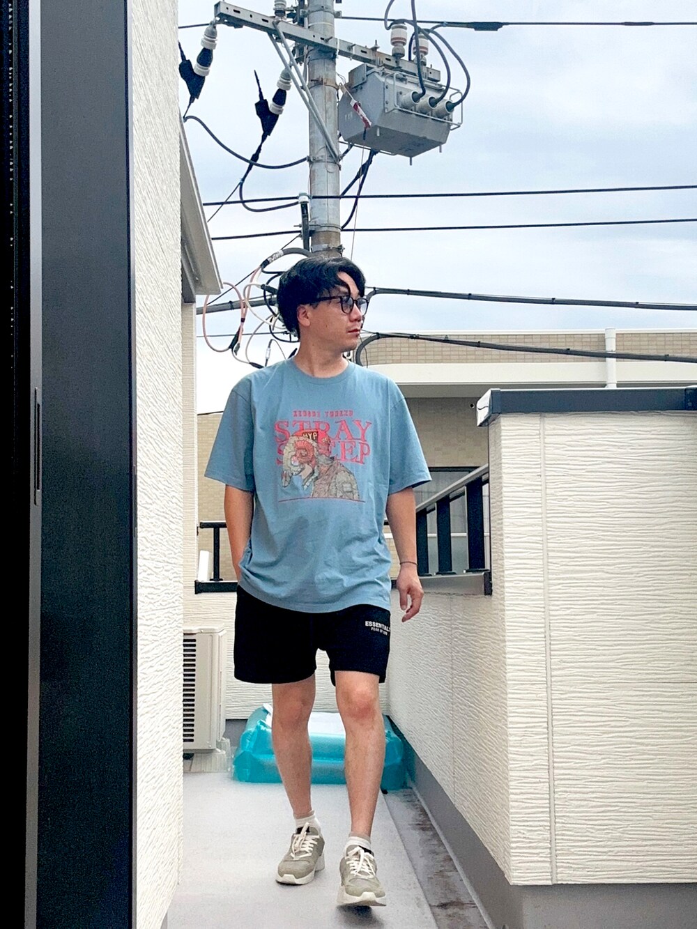 ブルー系のTシャツ/カットソー、ブラック系のスウェットパンツ、グレー系のスニーカーを着用したメンズの秋コーディネートの4枚目の写真