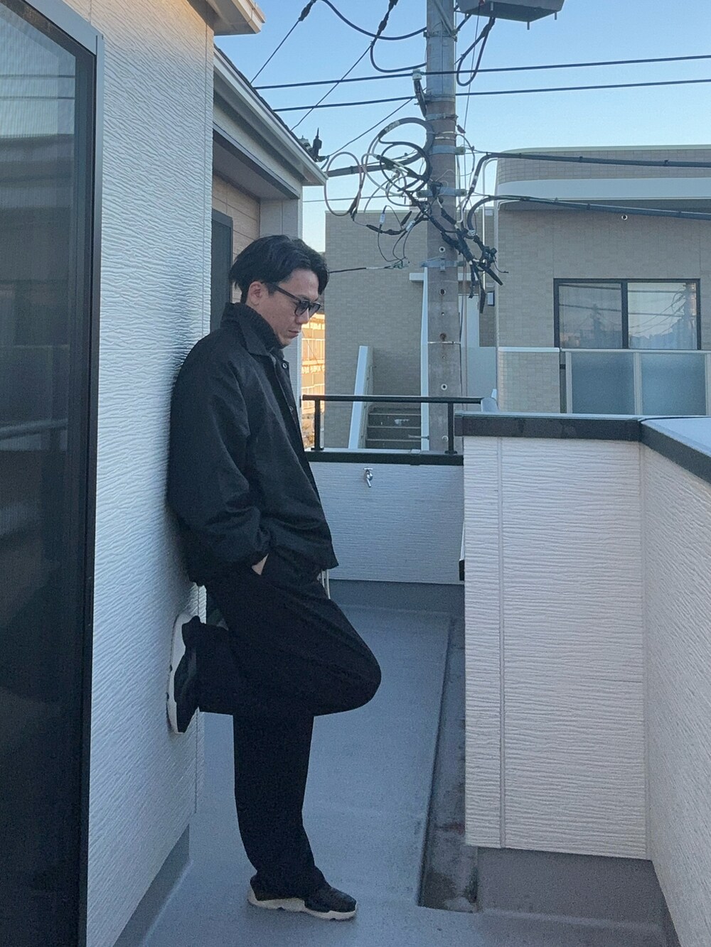 ブラック系のニット/セーター、ブラック系のナイロンジャケット、ブラック系のスニーカーを着用したメンズの秋コーディネートの3枚目の写真