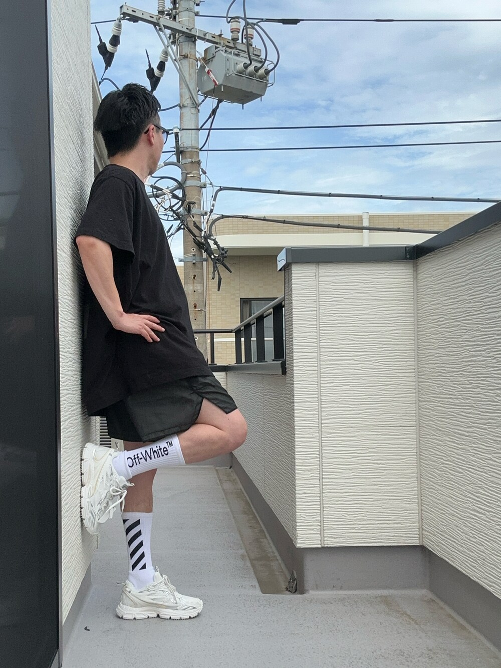 ブラック系のTシャツ/カットソー、ホワイト系のスニーカー、ブラック系のパンツを着用したメンズの夏コーディネートの3枚目の写真