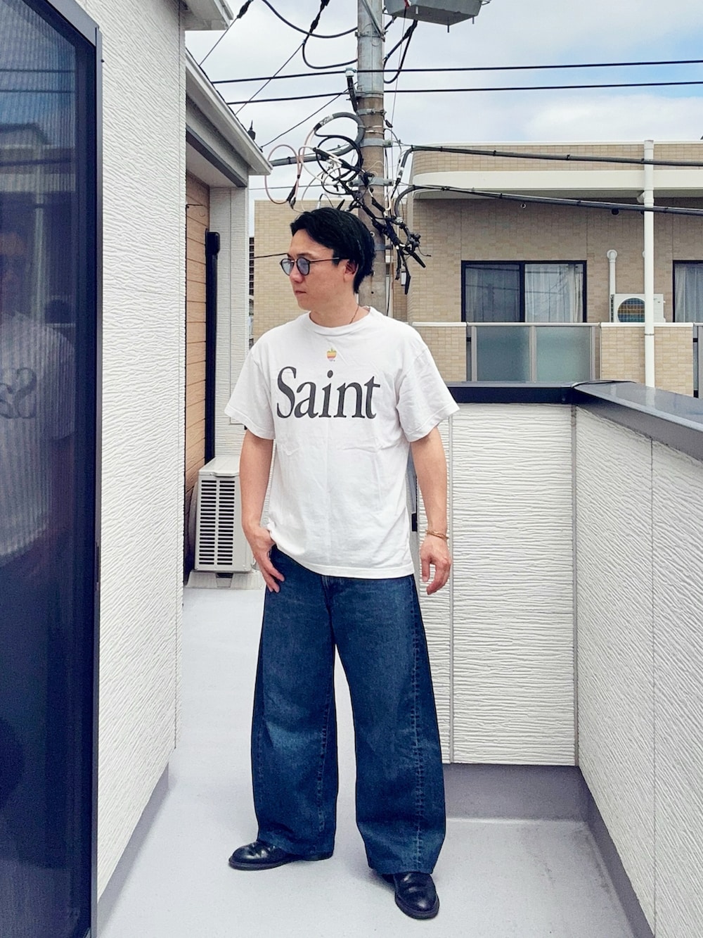 ホワイト系のTシャツ/カットソー、ブルー系のデニムパンツ、ブラック系のブーツを着用したメンズの夏コーディネートの2枚目の写真