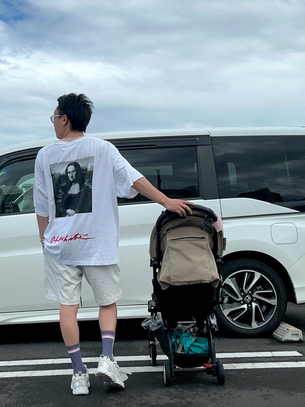 ブラック系のスニーカー、ホワイト系のTシャツ/カットソー、ブラック系のTシャツ/カットソーを着用したメンズの夏コーディネートの3枚目の写真