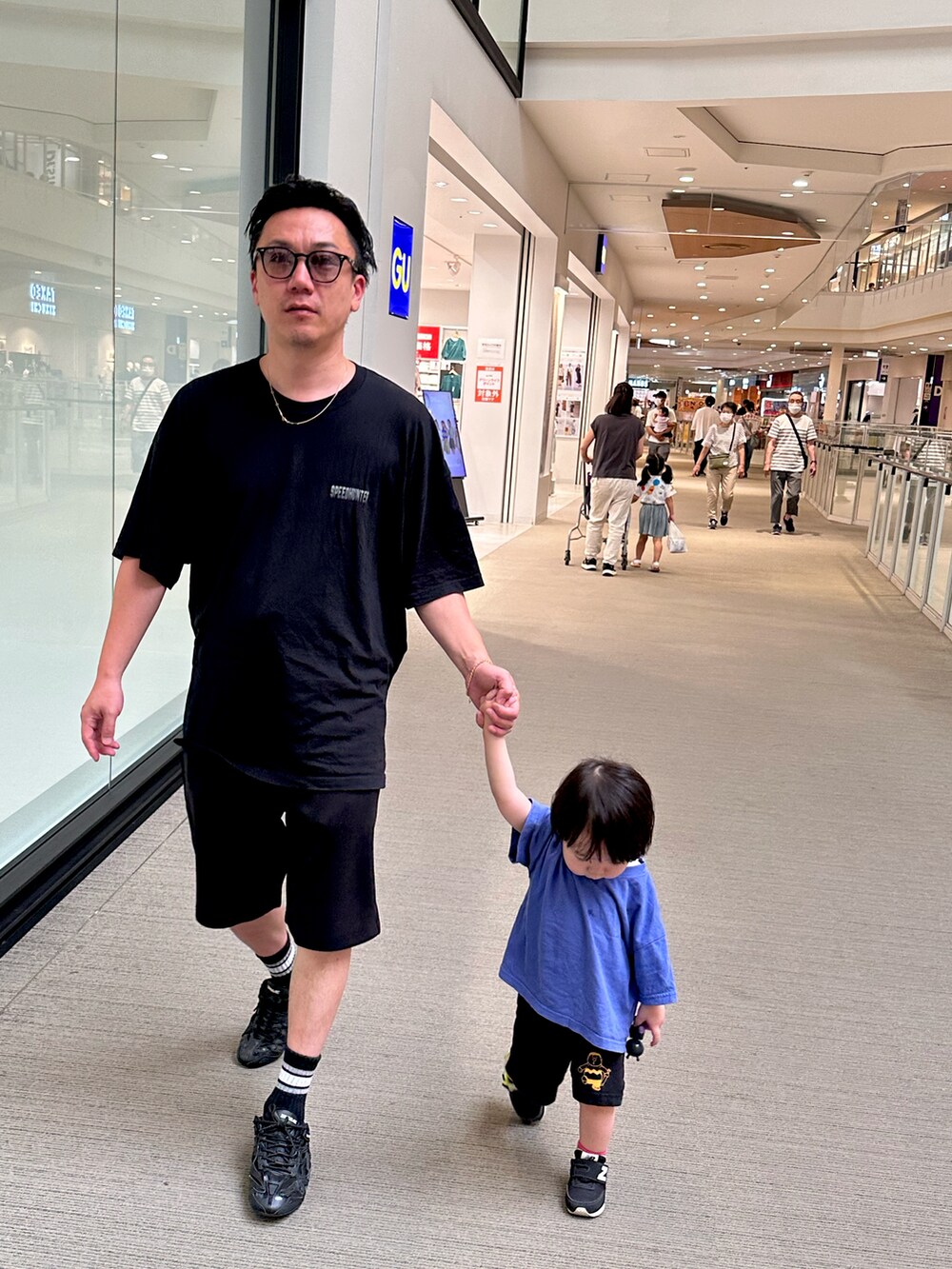 ブラック系のスニーカー、ブラック系のTシャツ/カットソー、ブラック系のスウェットパンツを着用したメンズの夏コーディネートの2枚目の写真
