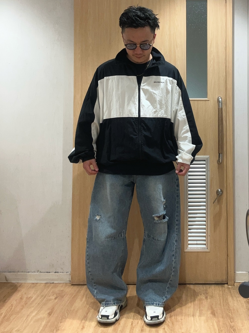 ブルー系のデニムパンツ、ブラック系のTシャツ/カットソー、ブラック系のナイロンジャケットを着用したメンズの秋コーディネートの3枚目の写真