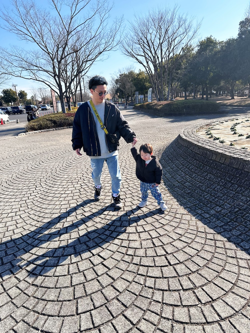 ブラック系のMA-1、ブルー系のデニムパンツ、ブラック系のショルダーバッグを着用したメンズの冬コーディネートの2枚目の写真