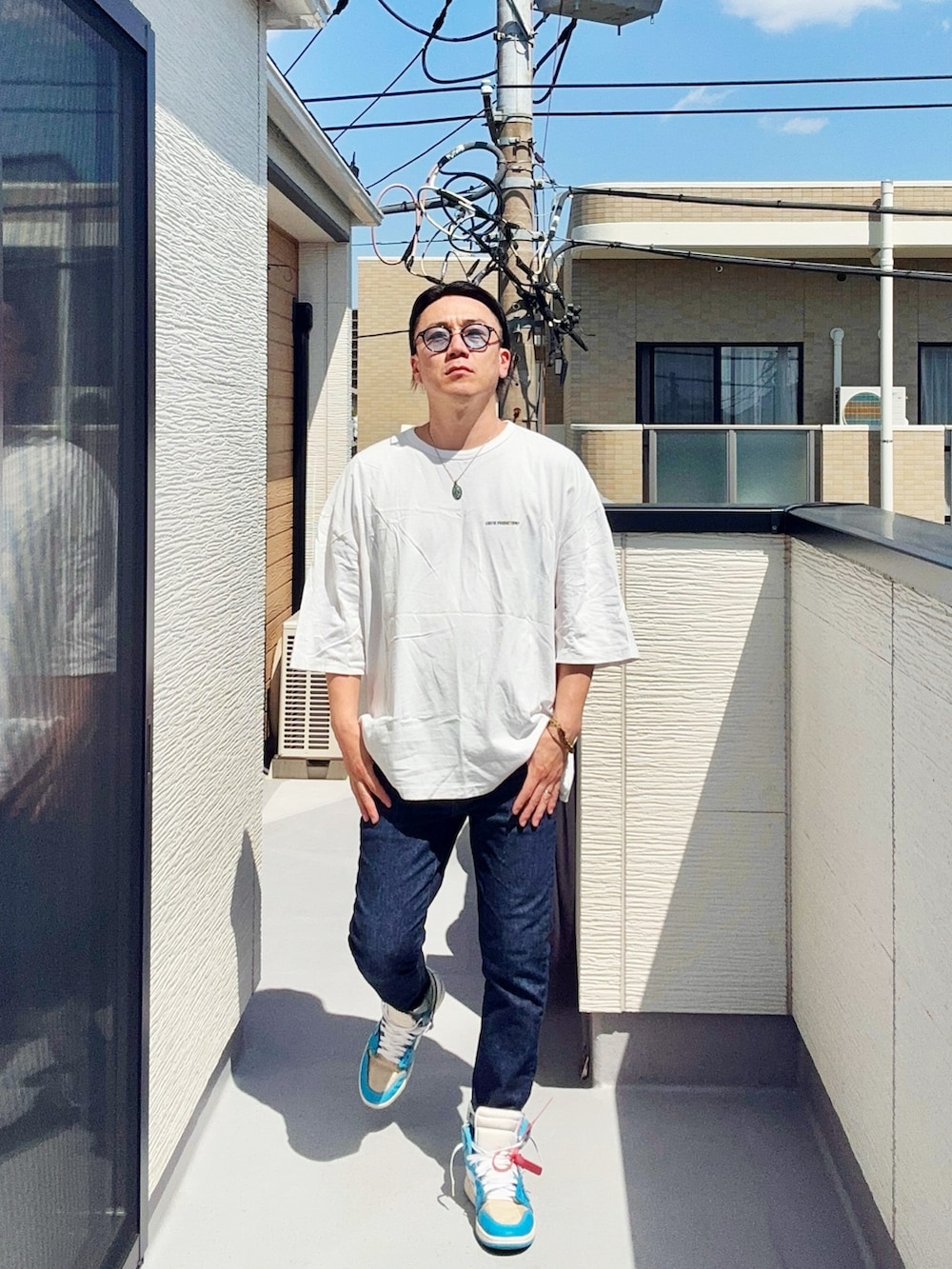 ホワイト系のTシャツ/カットソー、ブルー系のデニムパンツ、ブルー系のスニーカーを着用したメンズの春コーディネートの3枚目の写真