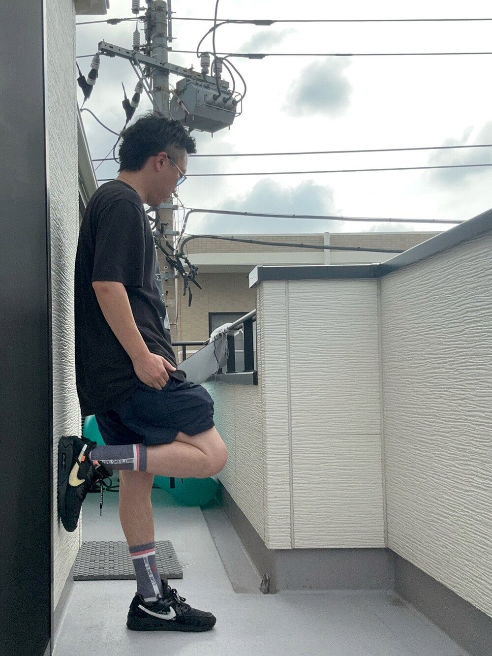 ブラック系のTシャツ/カットソー、ブルー系のパンツ、ブラック系のスニーカーを着用したメンズの夏コーディネートの4枚目の写真