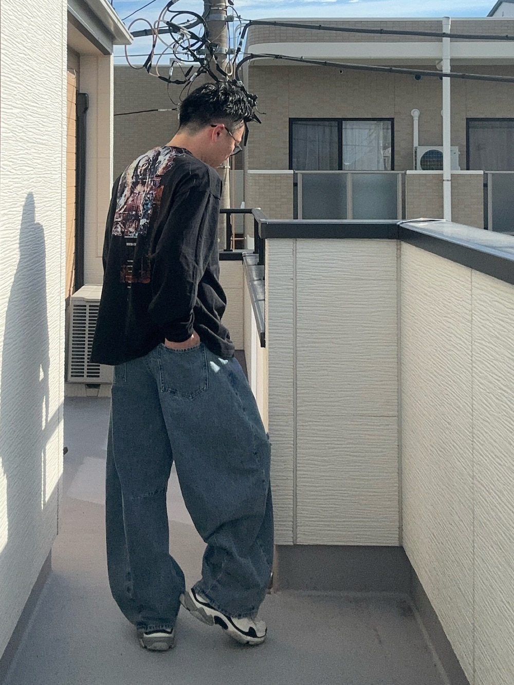 ブルー系のデニムパンツ、ブラック系のTシャツ/カットソー、ホワイト系のシューズを着用したメンズの秋コーディネートの2枚目の写真