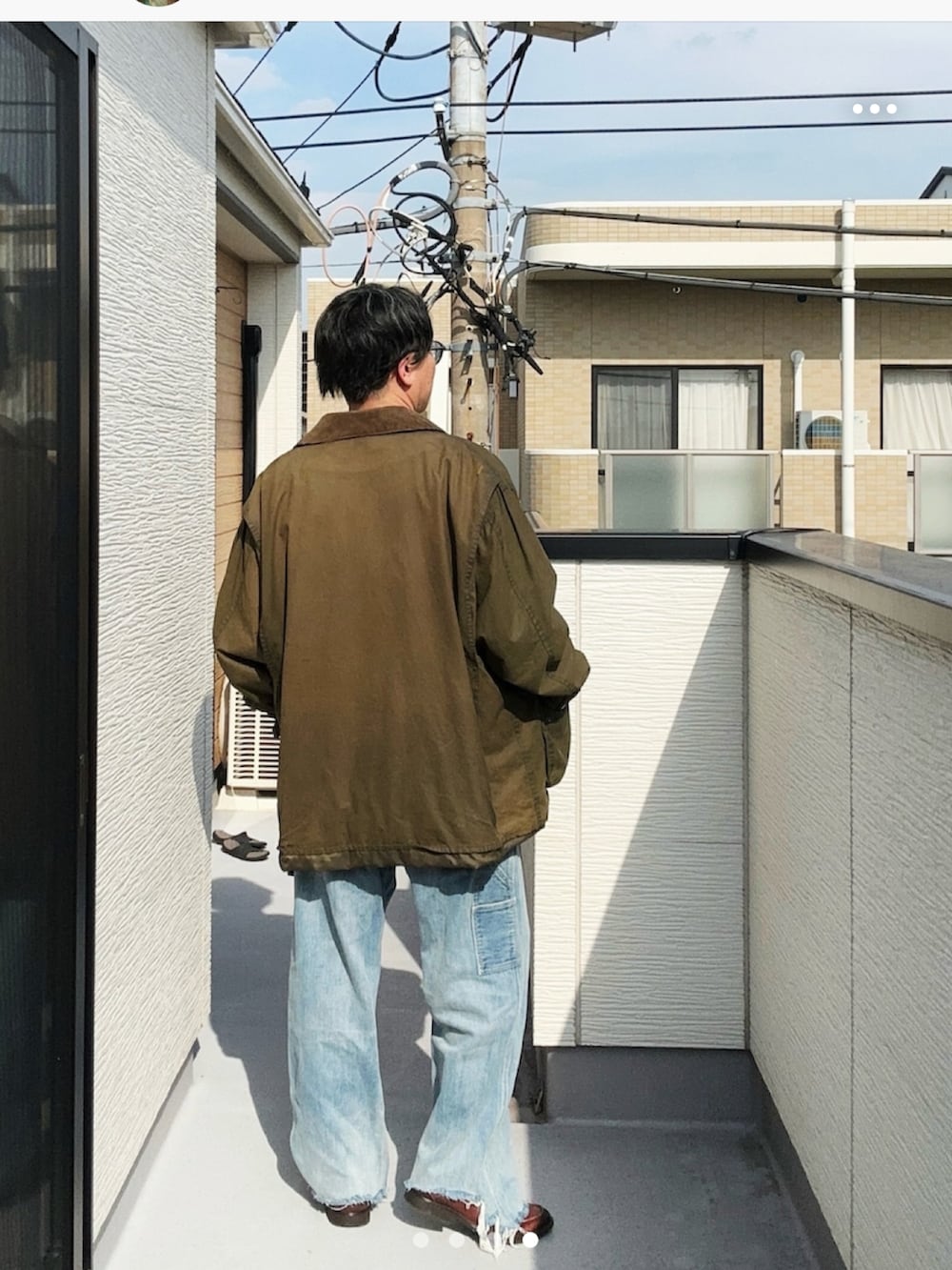 ブルー系のデニムパンツ、ブラック系のTシャツ/カットソー、グリーン系のジャケット/アウターを着用したメンズの秋コーディネートの3枚目の写真