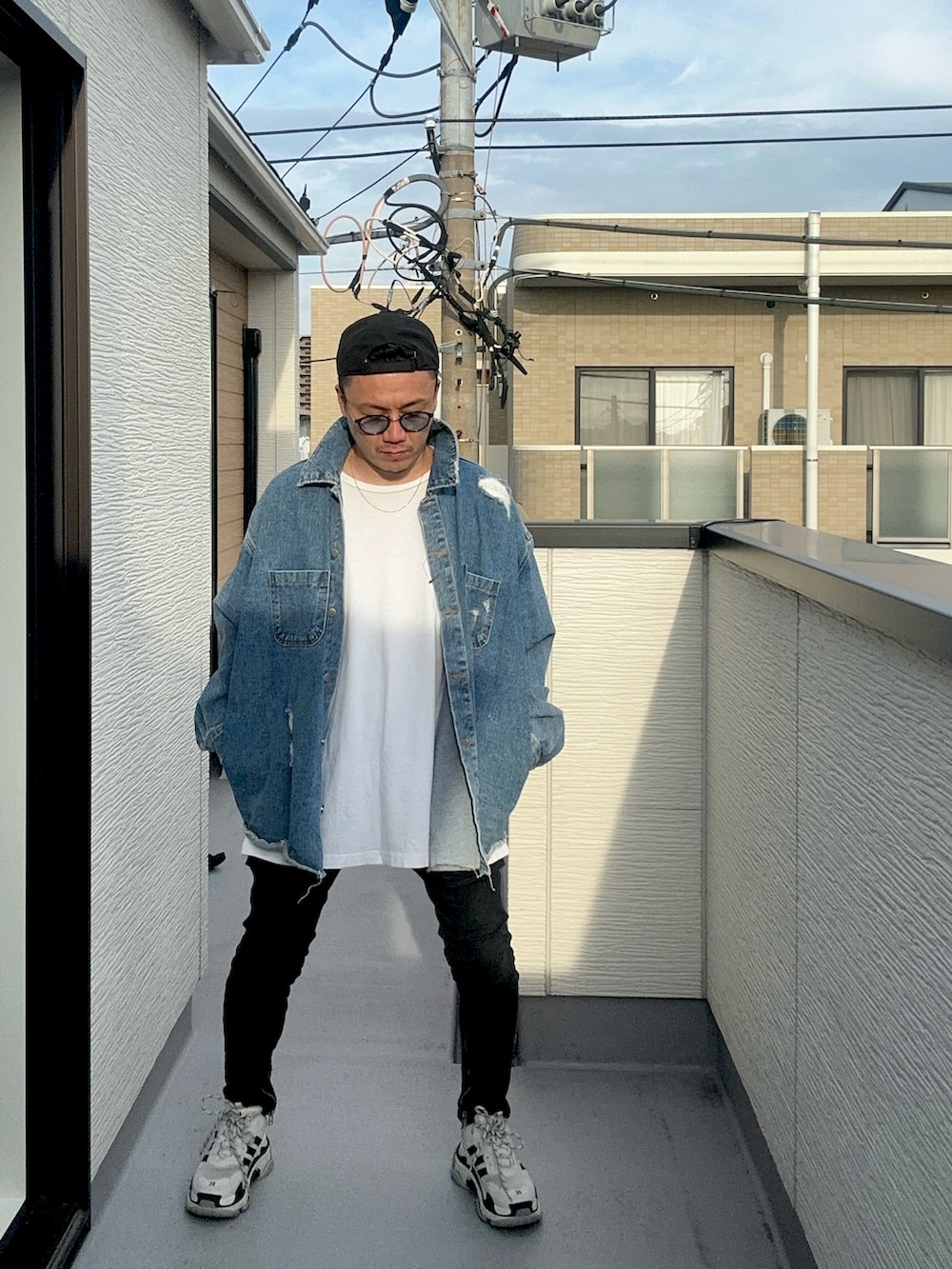 ホワイト系のTシャツ/カットソー、ブルー系のデニムジャケット、ブラック系のデニムパンツを着用したメンズの秋コーディネートの2枚目の写真