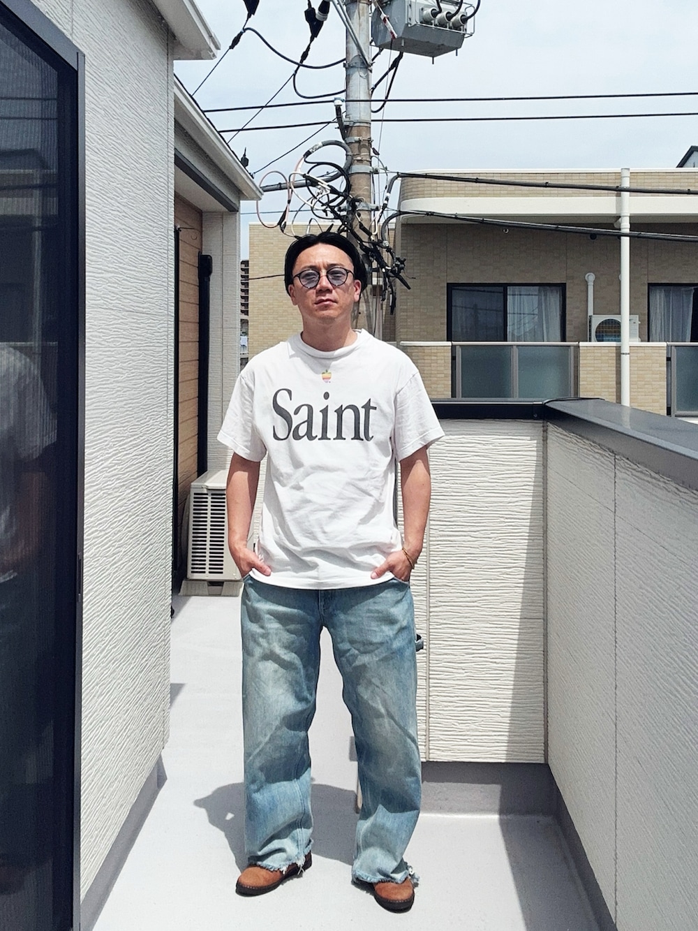 ブルー系のデニムパンツ、ホワイト系のTシャツ/カットソー、ブラウン系のドレスシューズを着用したメンズの夏コーディネートの2枚目の写真