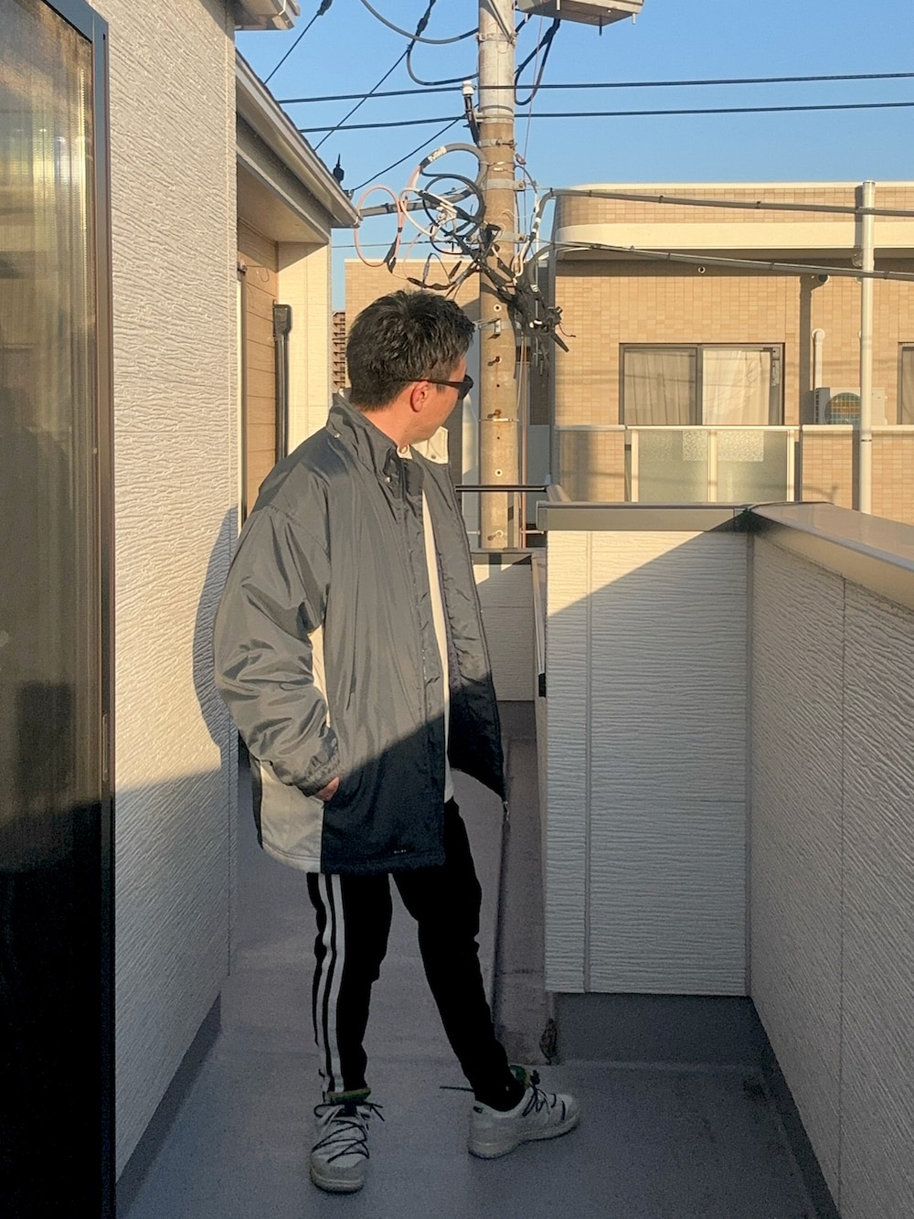 ベージュ系のスウェット、ブルー系のジャケット/アウター、ブラック系のパンツを着用したメンズの冬コーディネートの5枚目の写真