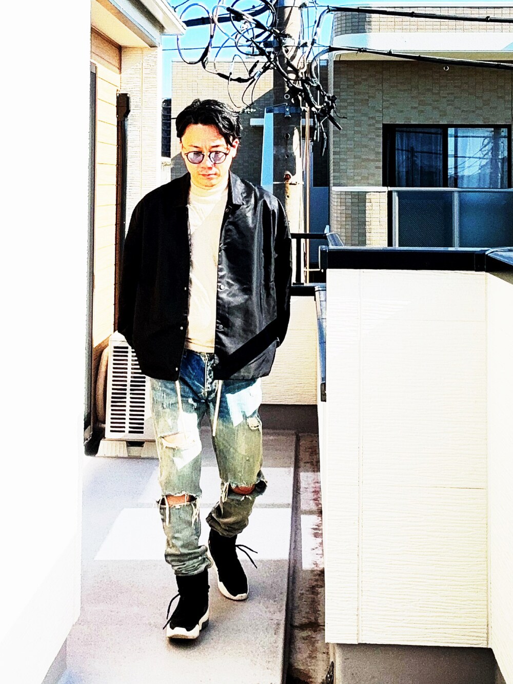 ブラック系のナイロンジャケット、グレー系のTシャツ/カットソー、ブルー系のデニムパンツを着用したメンズの秋コーディネートの3枚目の写真