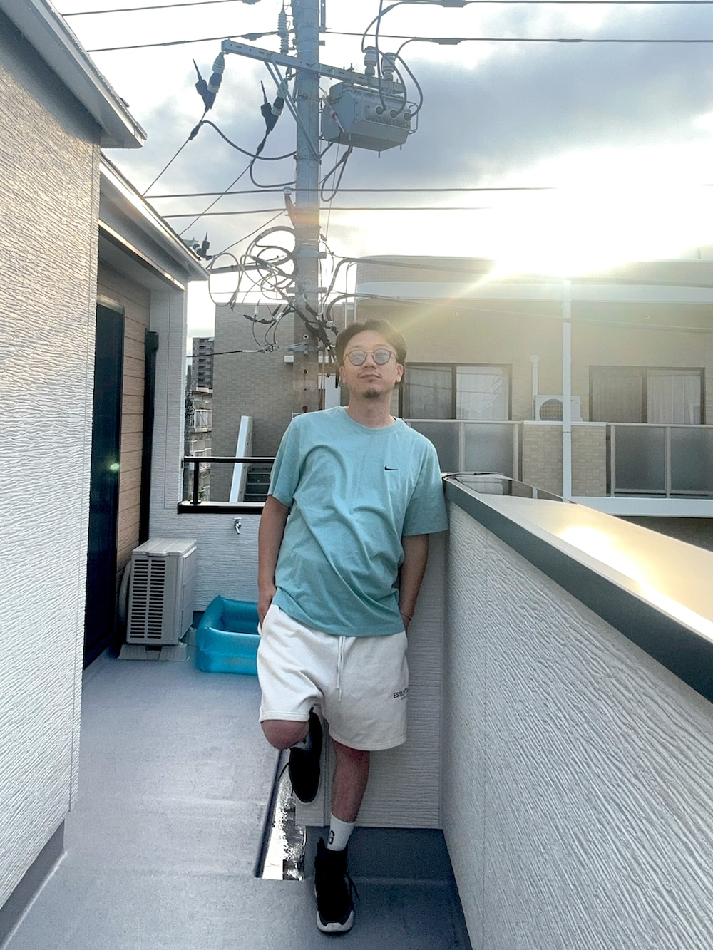 ブルー系のTシャツ/カットソー、ホワイト系のスウェットパンツ、ブラック系のスニーカーを着用したメンズの夏コーディネートの5枚目の写真