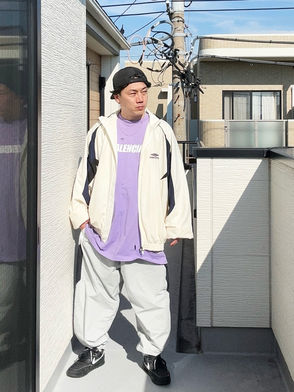グレー系のその他パンツ、パープル系のTシャツ/カットソー、ホワイト系のナイロンジャケットを着用したメンズの秋コーディネートの3枚目の写真