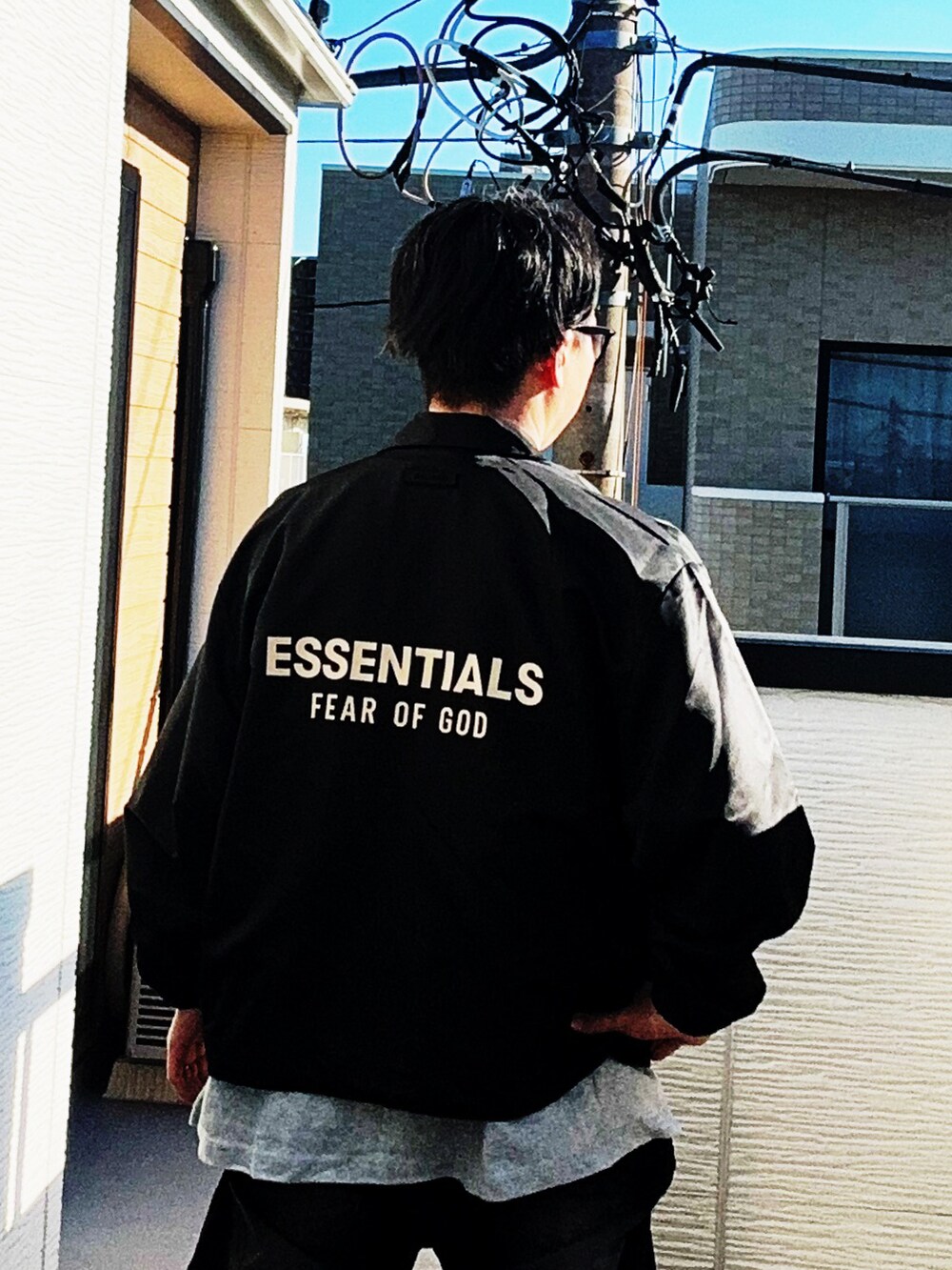 グレー系のTシャツ/カットソー、ブラック系のナイロンジャケット、ブラック系のデニムパンツを着用したメンズの秋コーディネートの2枚目の写真