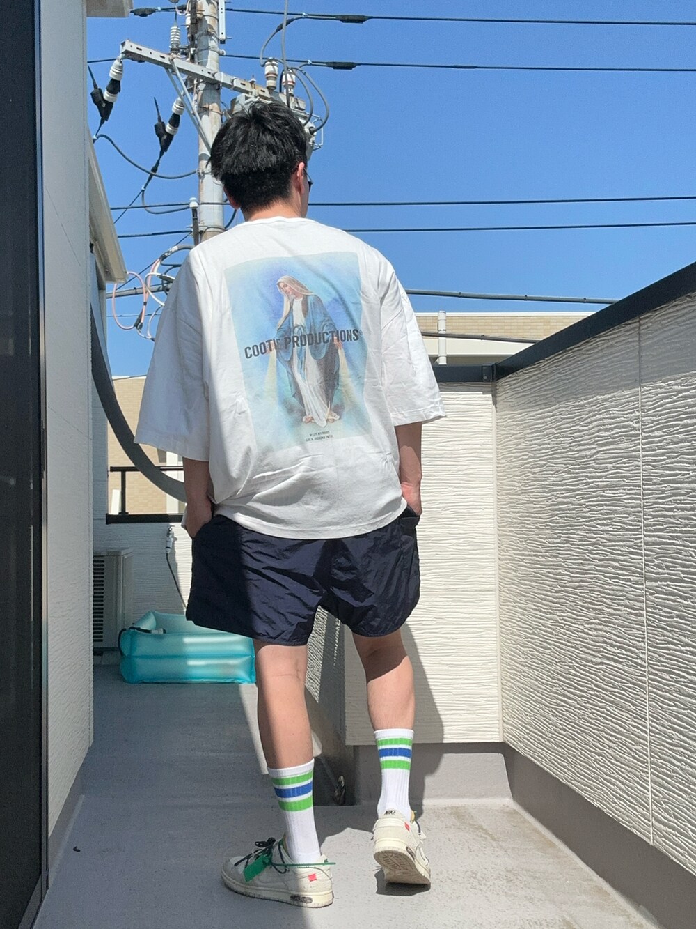 ホワイト系のTシャツ/カットソー、ブルー系のパンツ、ホワイト系のスニーカーを着用したメンズの夏コーディネートの5枚目の写真