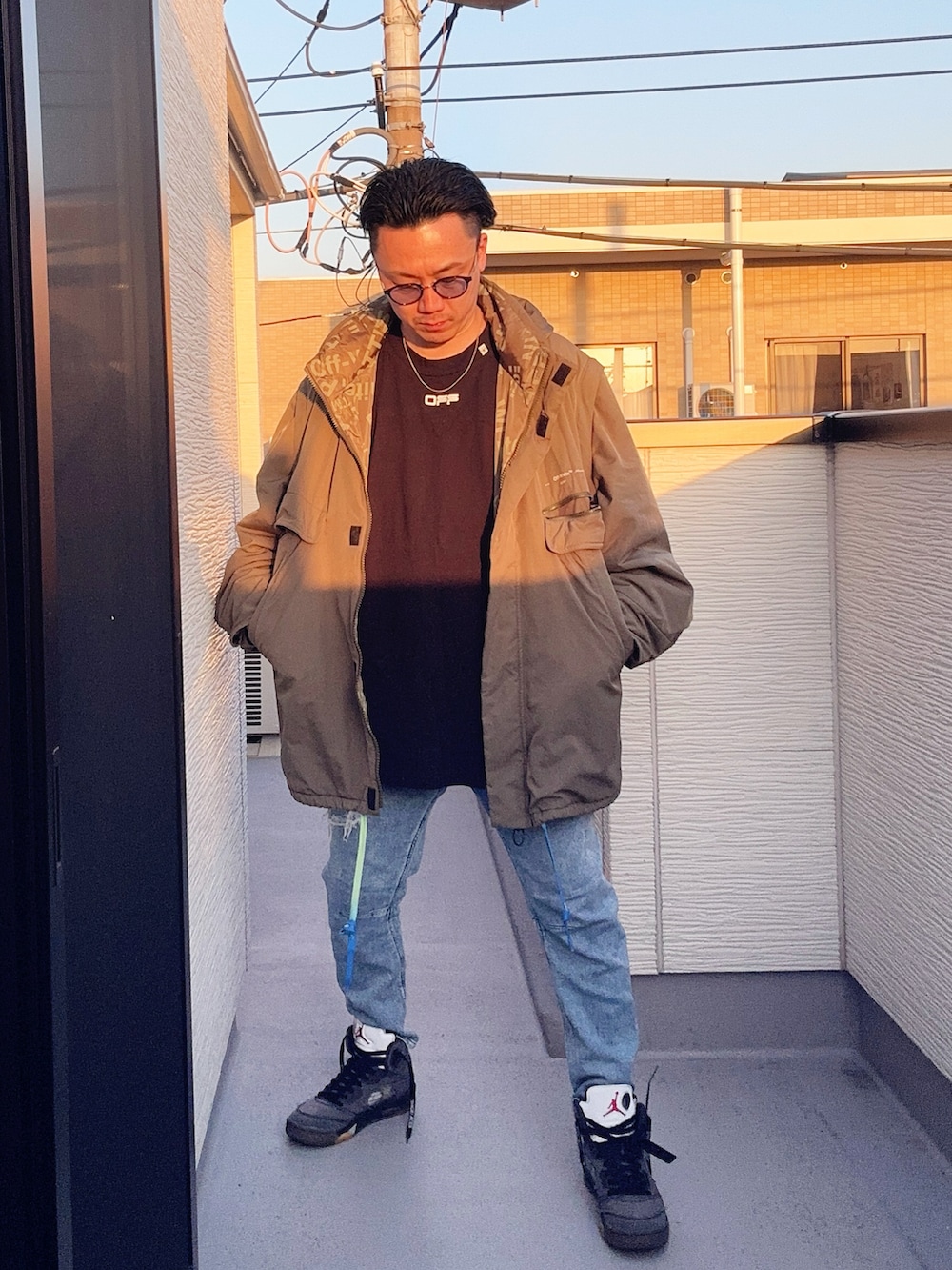 ブルー系のデニムパンツ、ブラック系のTシャツ/カットソー、グリーン系のミリタリージャケットを着用したメンズの冬コーディネートの2枚目の写真