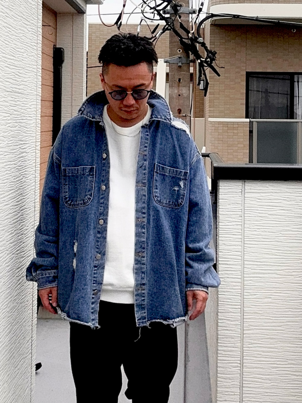 ブラック系のスラックス、ホワイト系のスウェット、ブルー系のデニムジャケットを着用したメンズの秋コーディネートの2枚目の写真