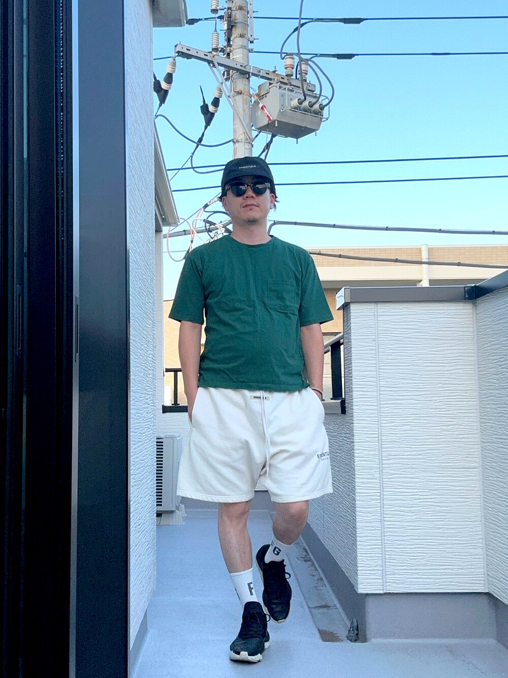 グリーン系のTシャツ/カットソー、ホワイト系のスウェットパンツ、ブラック系のスニーカーを着用したメンズの夏コーディネートの5枚目の写真