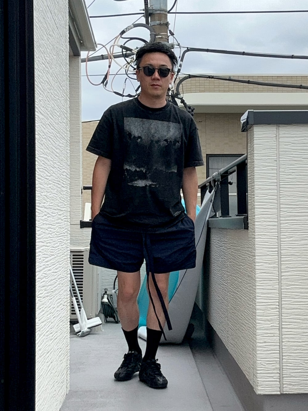 ブラック系のTシャツ/カットソー、ブルー系のパンツ、ブラック系のシューズを着用したメンズの夏コーディネートの3枚目の写真