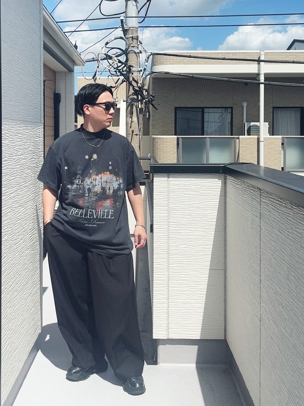 ブラック系のスラックス、ブラック系のTシャツ/カットソー、ブラック系のシューズを着用したメンズの夏コーディネートの2枚目の写真