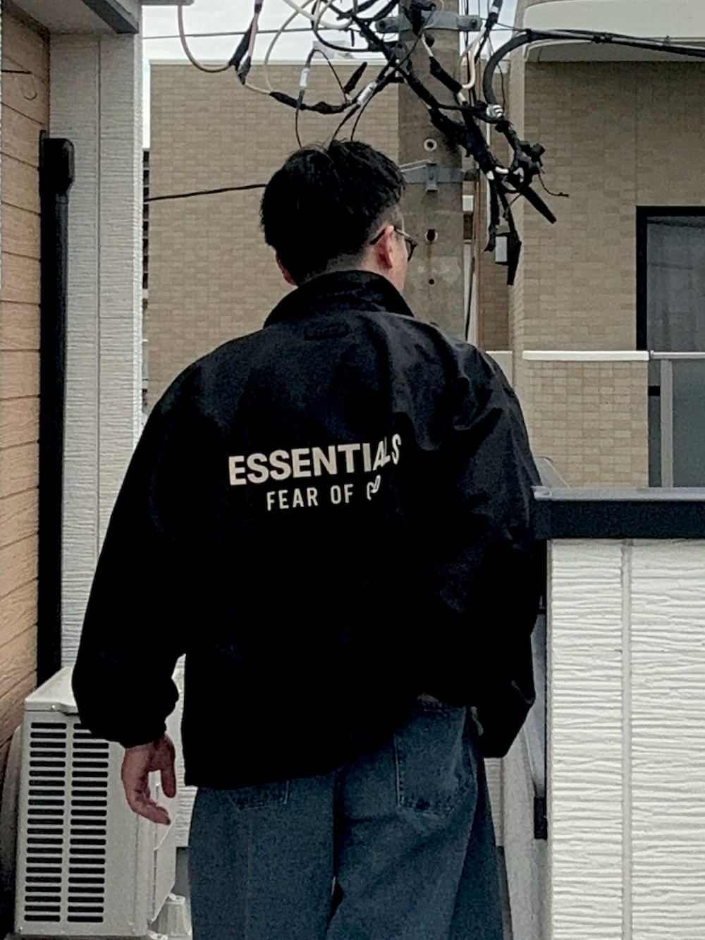 ブルー系のデニムパンツ、ブラック系のナイロンジャケット、ホワイト系のTシャツ/カットソーを着用したメンズの秋コーディネートの3枚目の写真