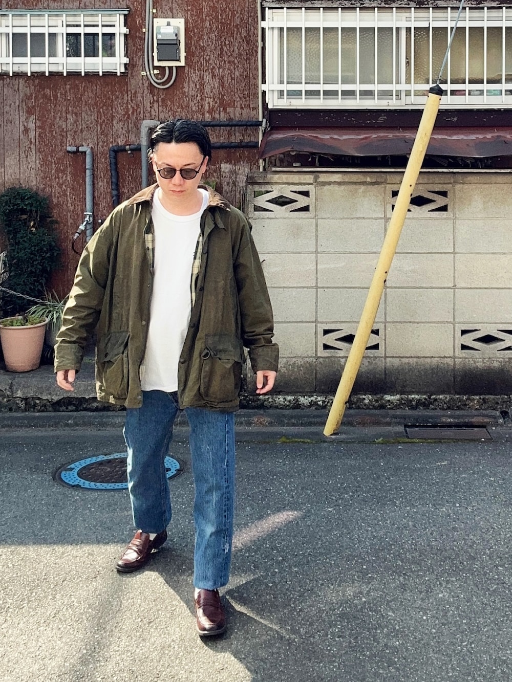 ブルー系のデニムパンツ、ホワイト系のTシャツ/カットソー、グリーン系のジャケット/アウターを着用したメンズの春コーディネートの2枚目の写真