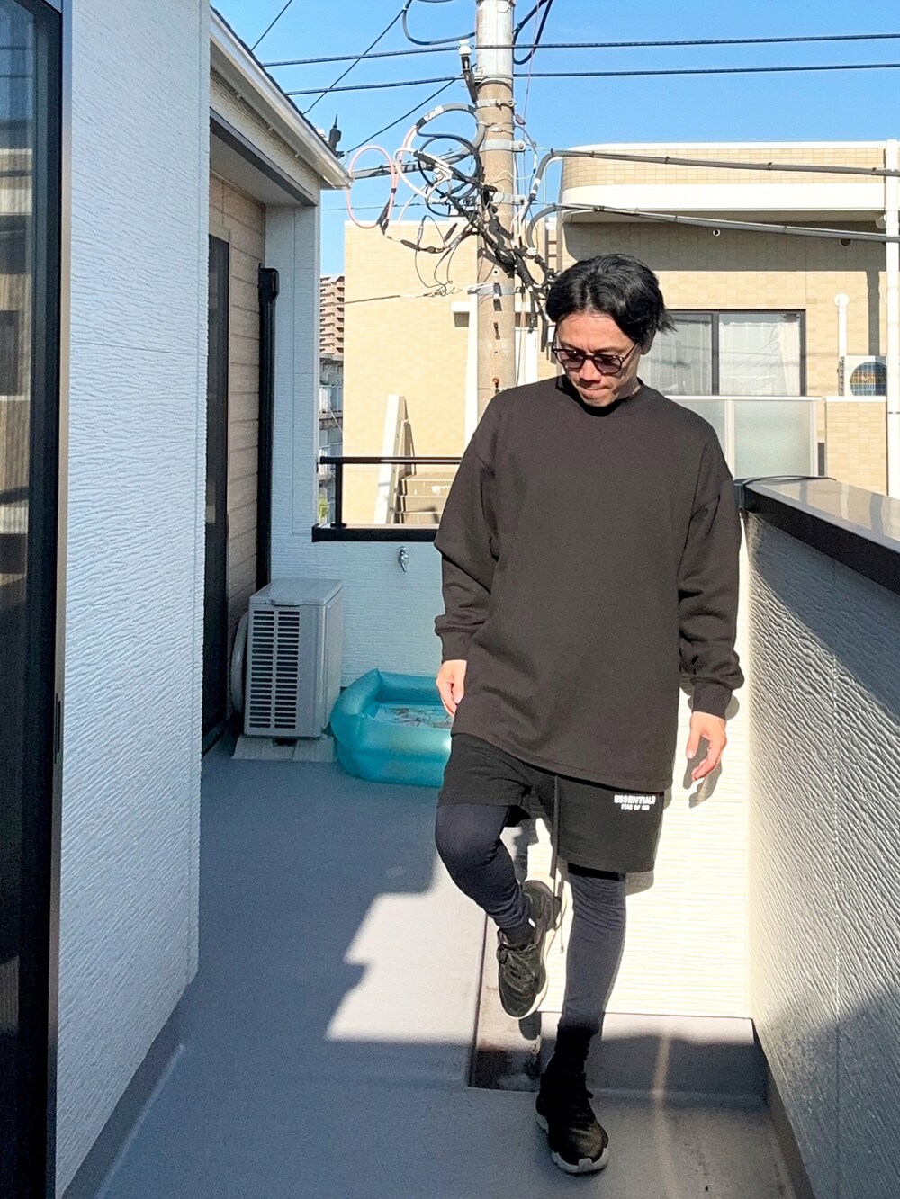 ブラック系のスウェットパンツ、ブラック系のスニーカー、ブラック系のスウェットを着用したメンズの秋コーディネートの4枚目の写真