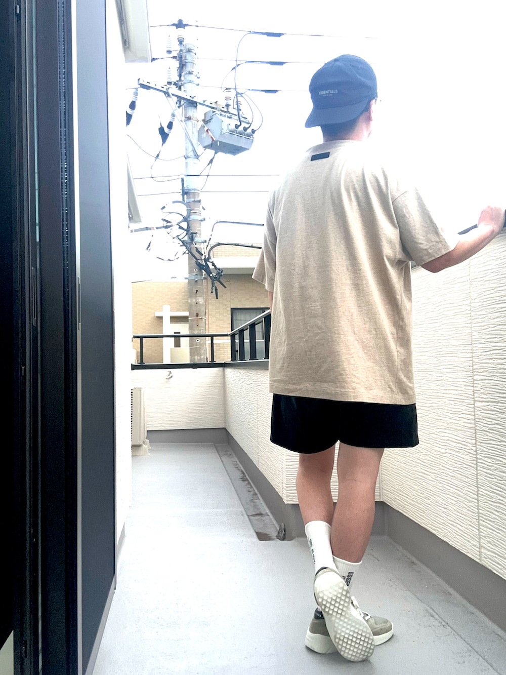 ベージュ系のTシャツ/カットソー、ブラック系のスウェットパンツ、グレー系のスニーカーを着用したメンズの夏コーディネートの3枚目の写真