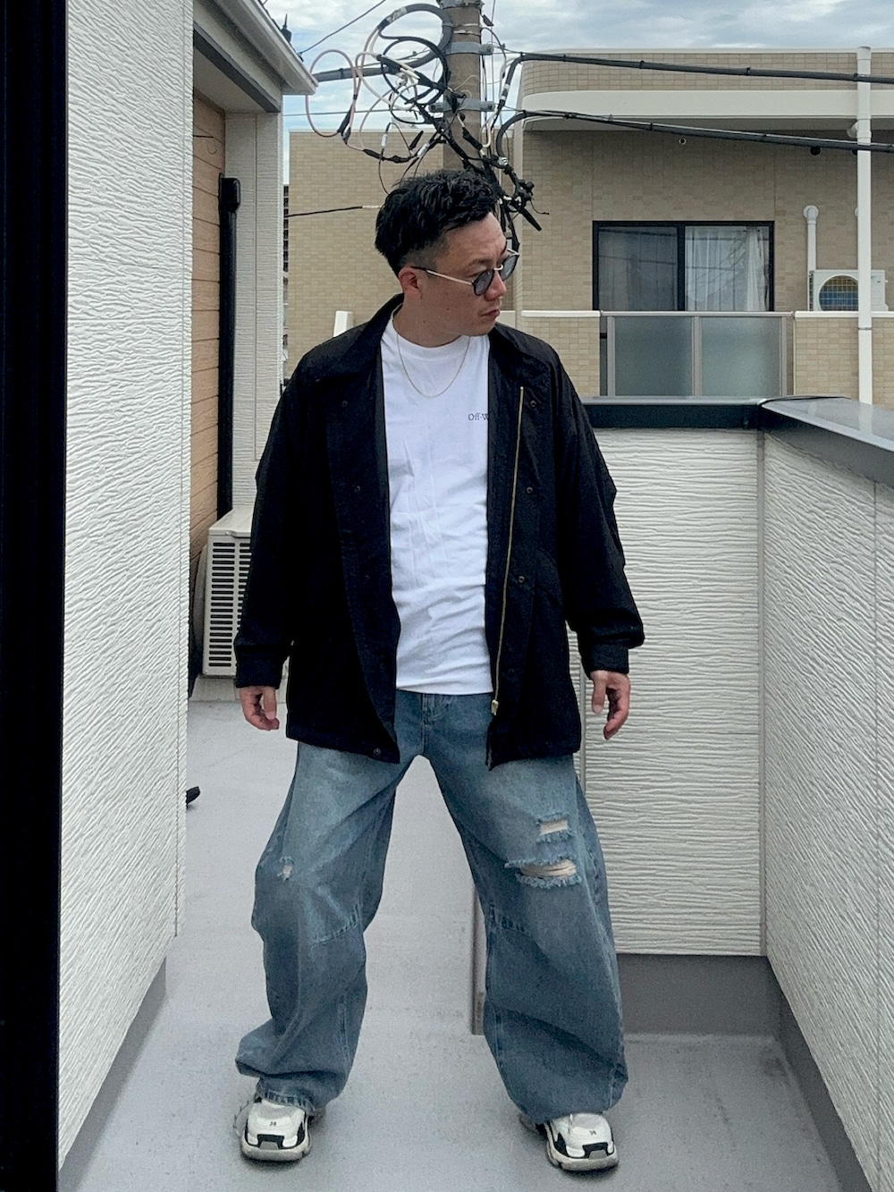 ブラック系のブルゾン、ブルー系のデニムパンツ、ホワイト系のTシャツ/カットソーを着用したメンズの秋コーディネートの2枚目の写真