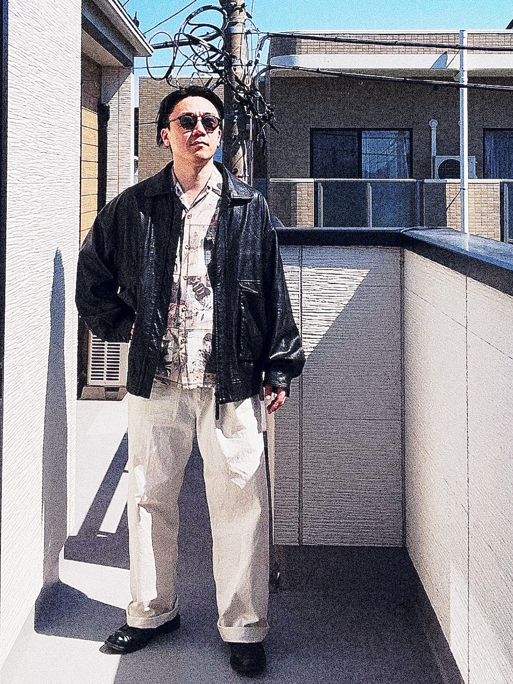 ブラック系のブルゾン、ベージュ系のシャツ/ブラウス、ホワイト系のチノパンツを着用したメンズの春コーディネートの3枚目の写真