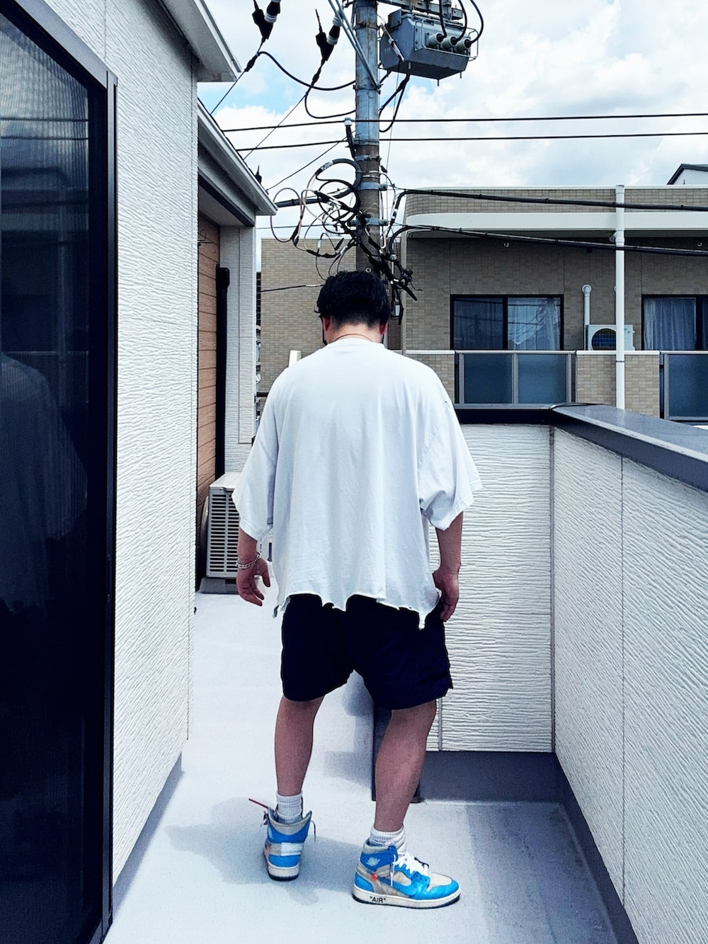 ホワイト系のTシャツ/カットソー、ブルー系のパンツ、ブルー系のスニーカーを着用したメンズの夏コーディネートの5枚目の写真