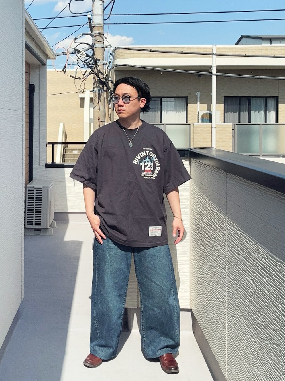 ブラック系のTシャツ/カットソー、ブルー系のデニムパンツ、ブラウン系のローファーを着用したメンズの春コーディネートの3枚目の写真