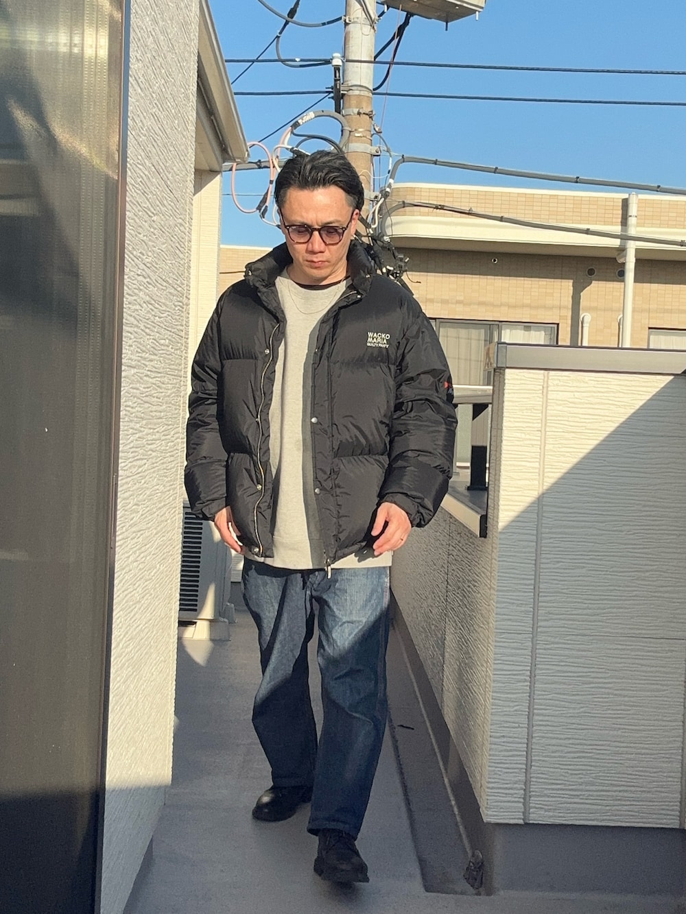 ブラック系のその他アウター、グレー系のスウェット、ブルー系のデニムパンツを着用したメンズの冬コーディネートの3枚目の写真