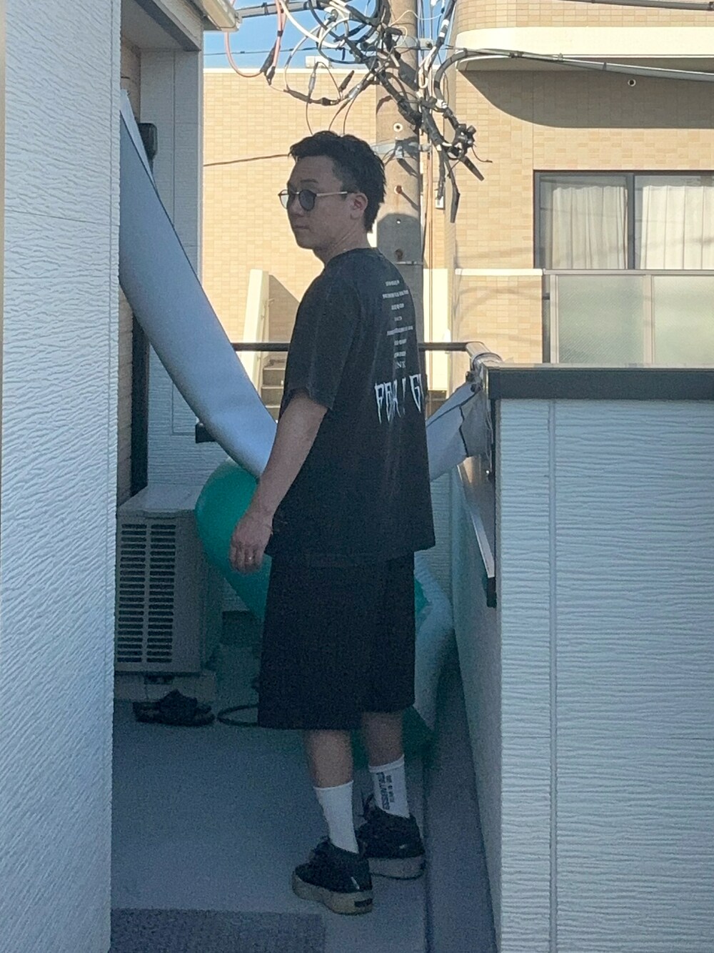 ブラック系のTシャツ/カットソー、ブラック系のスウェットパンツ、ブラック系のスニーカーを着用したメンズの夏コーディネートの3枚目の写真