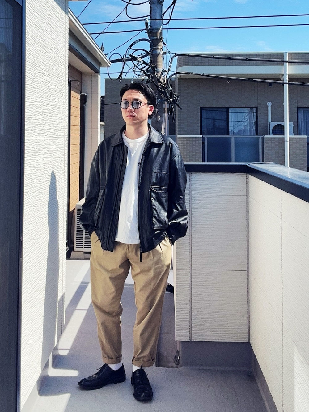 ブラック系のブルゾン、グリーン系のチノパンツ、ホワイト系のTシャツ/カットソーを着用したメンズの春コーディネートの2枚目の写真