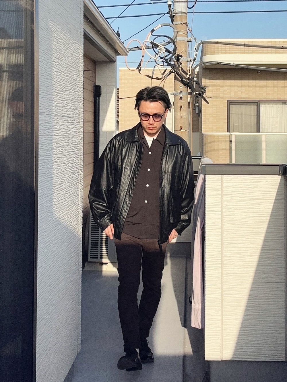 ブラック系のブルゾン、ブラウン系のその他パンツ、ブラック系のシャツ/ブラウスを着用したメンズの春コーディネートの2枚目の写真