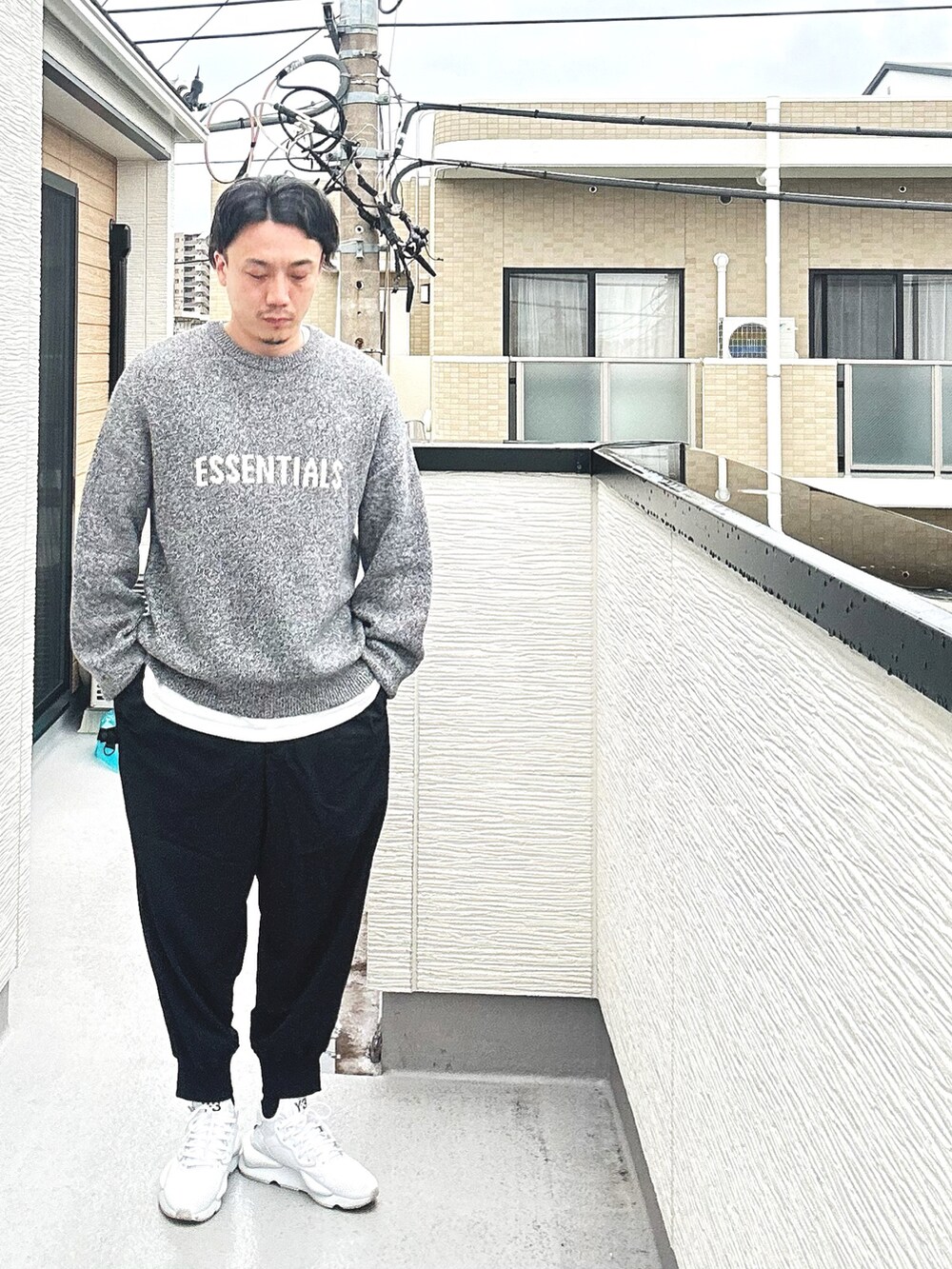 グレー系のニット/セーター、ブラック系のその他パンツ、ホワイト系のTシャツ/カットソーを着用したメンズの秋コーディネートの2枚目の写真