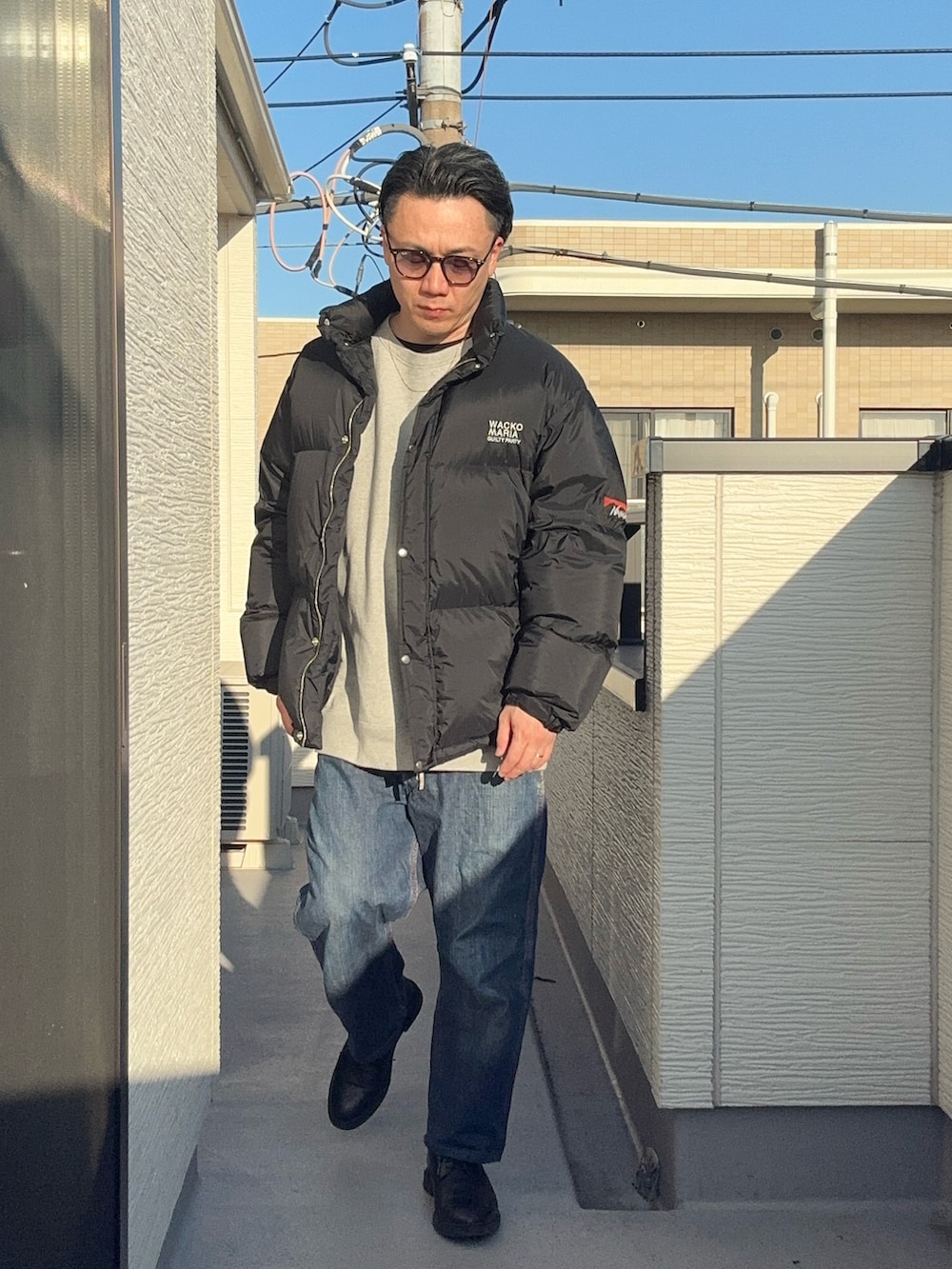 ブラック系のその他アウター、グレー系のスウェット、ブルー系のデニムパンツを着用したメンズの冬コーディネートの2枚目の写真