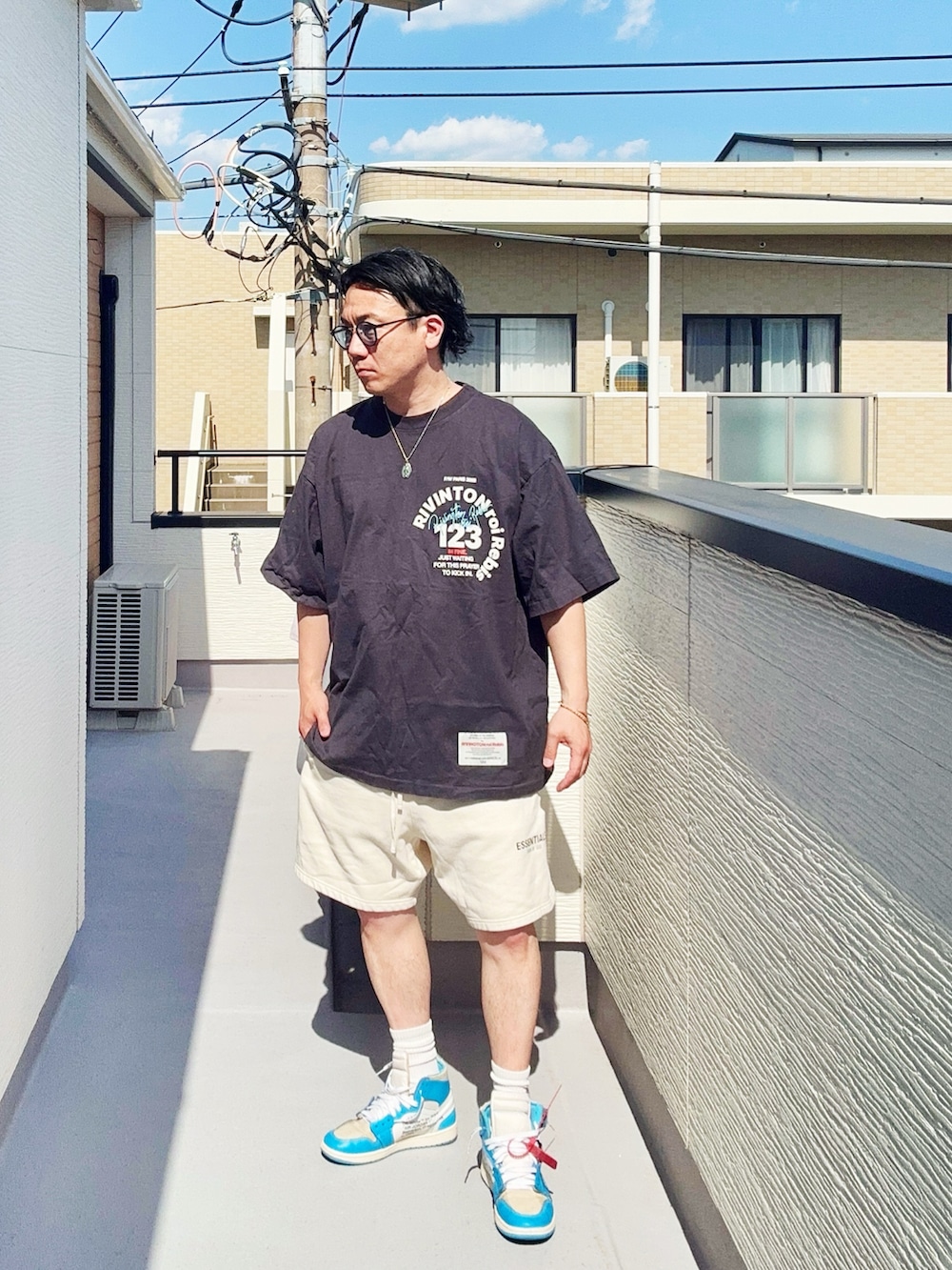 ブラック系のTシャツ/カットソー、ホワイト系のスウェットパンツ、ブルー系のスニーカーを着用したメンズの春コーディネートの3枚目の写真