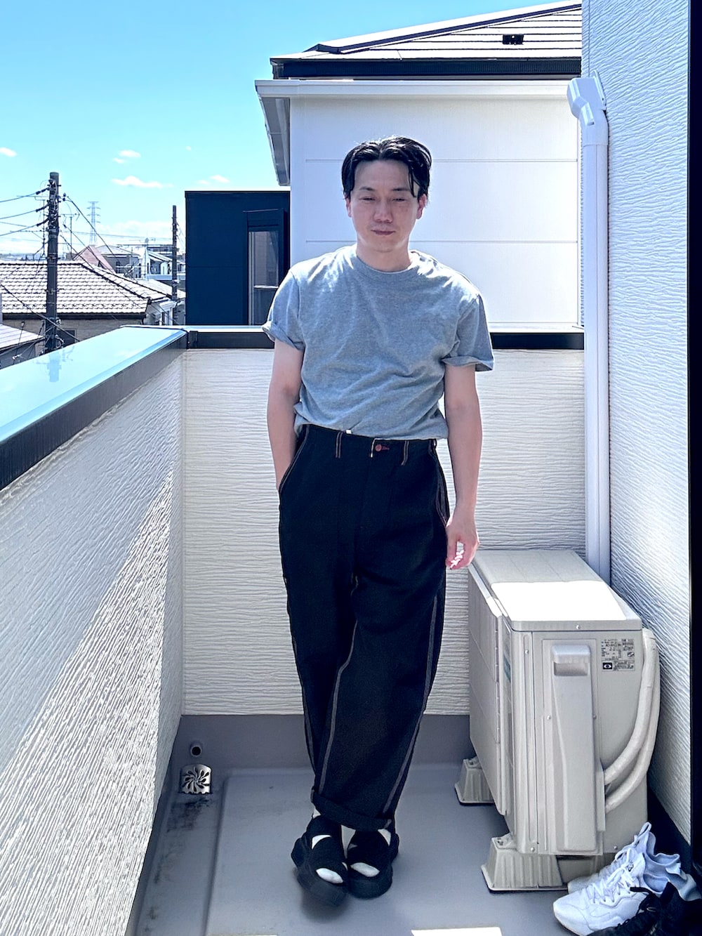 グレー系のTシャツ/カットソー、ブラック系のデニムパンツ、ブラック系のサンダルを着用したメンズの夏コーディネートの3枚目の写真