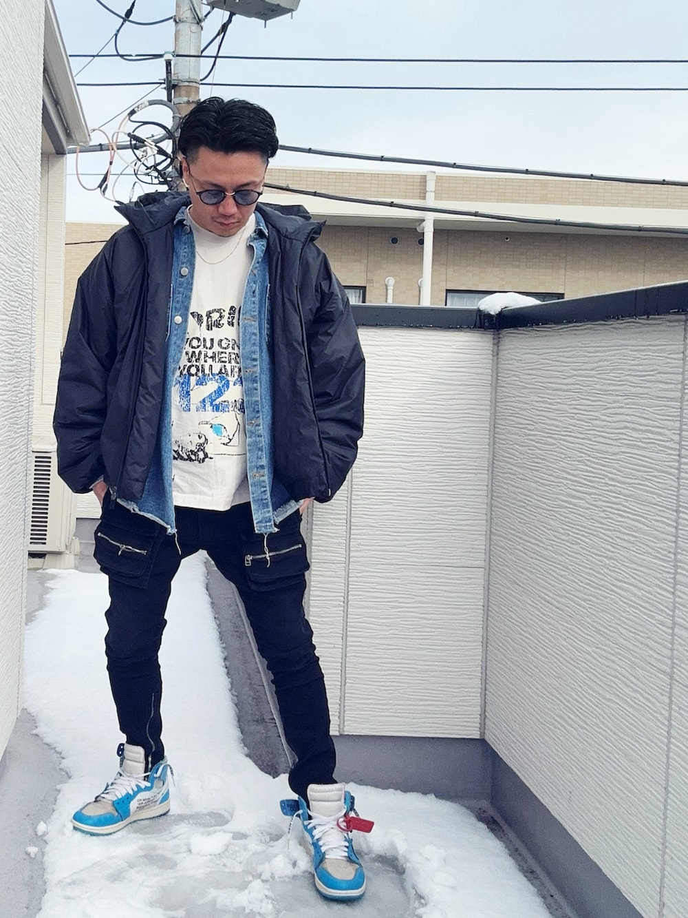 ホワイト系のTシャツ/カットソー、ブルー系のデニムジャケット、ブラック系のジャケット/アウターを着用したメンズの冬コーディネートの2枚目の写真