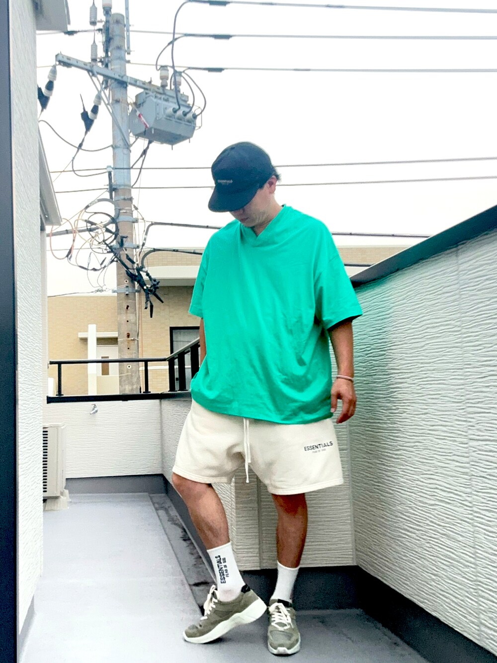 ホワイト系のスウェットパンツ、グレー系のスニーカー、グリーン系のTシャツ/カットソーを着用したメンズの夏コーディネートの2枚目の写真